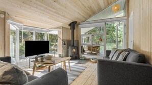 Un salon chaleureux avec une cheminée, un téléviseur et des fauteuils confortables.