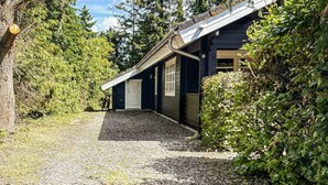 Rakennus, jonka eteen johtaa sorapäällysteinen ajotie, ja jonka ympärillä on tiheää kasvillisuutta.