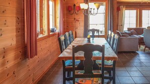 Un intérieur en bois avec une longue table à manger, des chaises et un canapé.
