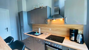 Eine moderne Küche mit Einbauofen, Kochfeld und Kaffeemaschine.