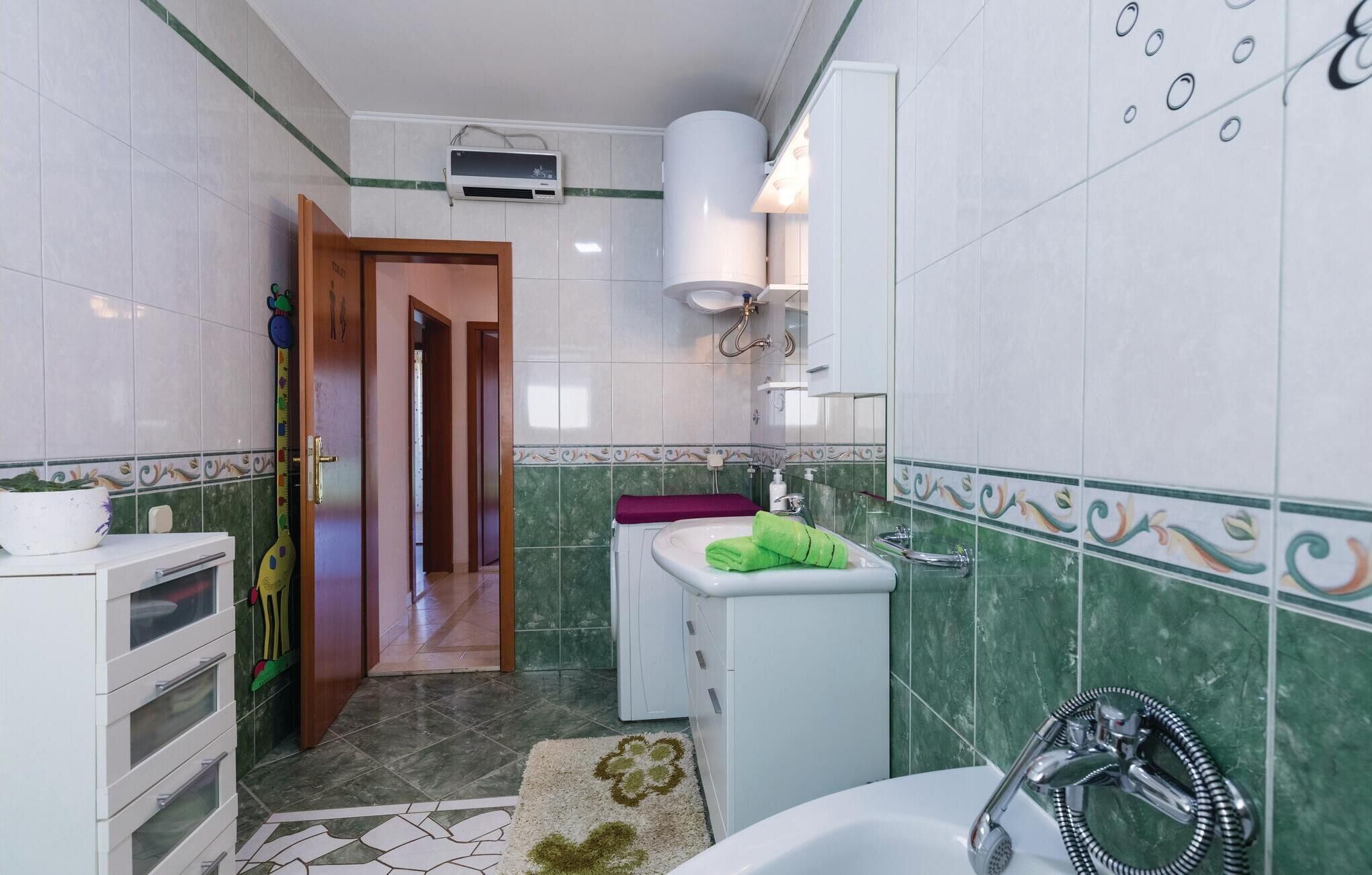 A bathroom with a shower, sink, and toilet. There is a towel rack and a mirror.