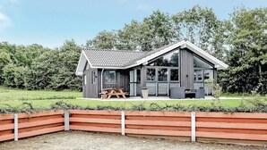 A modern cabin with a sloped roof, large windows, and a patio area. - Awesome home in Haderslev with sauna (Haderslev)