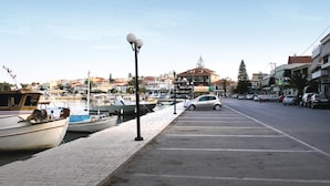 Un port de plaisance avec des bateaux amarrés, un parking et des bâtiments en arrière-plan.