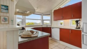 A kitchen with a central island, white cabinetry, and a view of the outside. - Beautiful home in Rønde with sauna (Rønde)