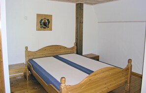 A single-bed room with a wooden headboard, a small bedside table, and a wall-mounted picture. - Pet friendly home in Skillingaryd (Skillingaryd)