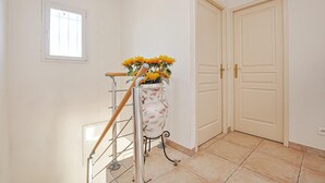Eine Treppe mit Handlauf, einem Wandfenster und einer Tür mit Griff.