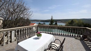 A terrace with a table and chairs, overlooking a body of water and hills. - Holiday apartment mit Klimaanlage und Meerblick (Čižići)