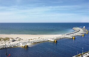 A coastal pier extending into the sea with a sandy beach and rocky outcrops nearby. - Gorgeous apartment in Kolobrzeg with WiFi (Kolobrzeg)