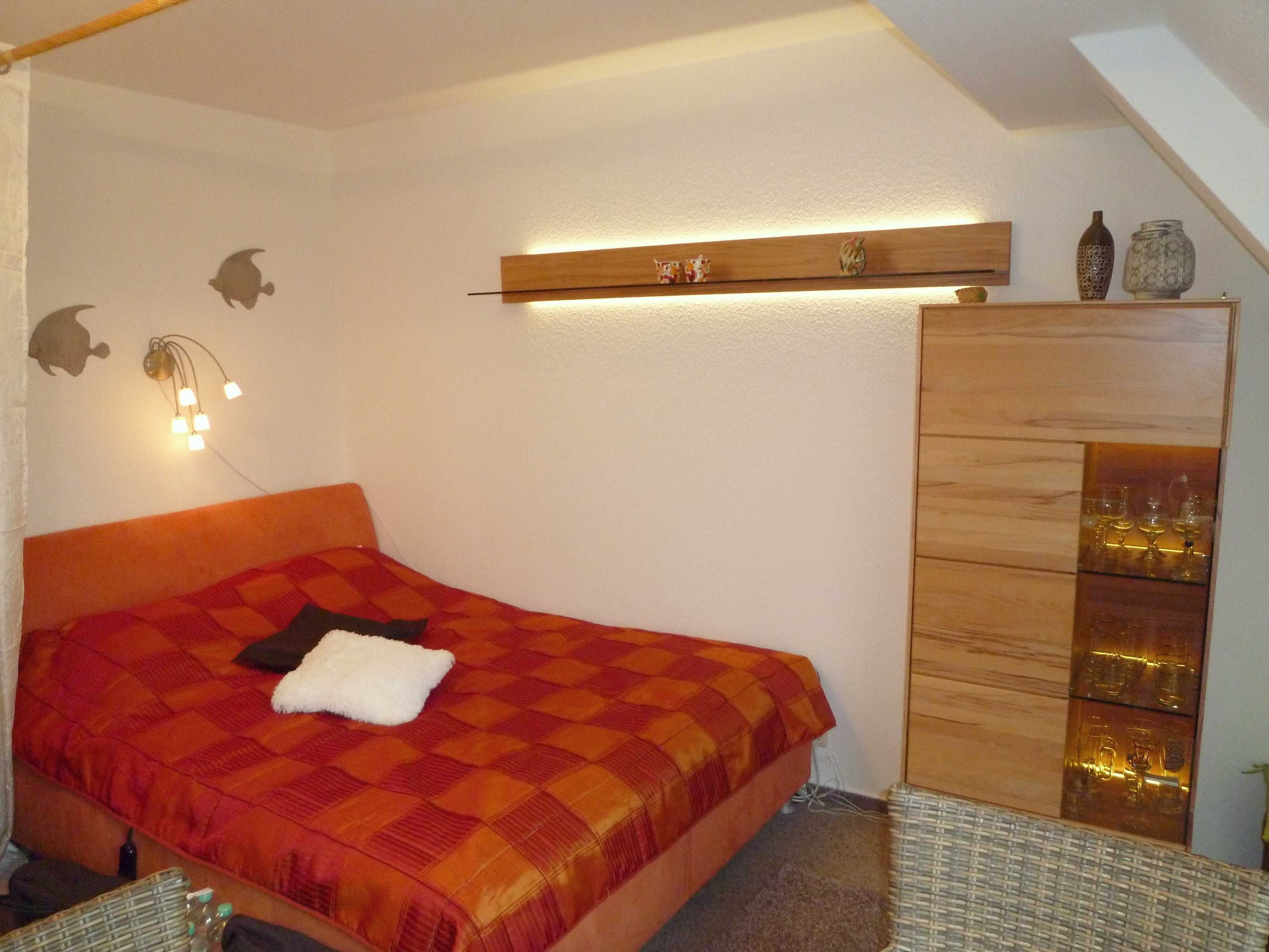 Ein Schlafzimmer mit einem Bett, einem Schminktisch und Wanddekorationen.