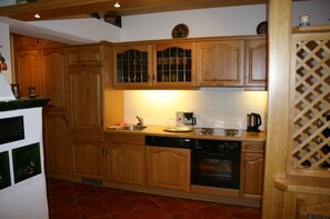 Una cocina con armarios de madera, lavavajillas, horno y cafetera.