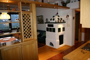 A cozy living room with a fireplace, wooden shelves, and a dining area with a table and chairs.