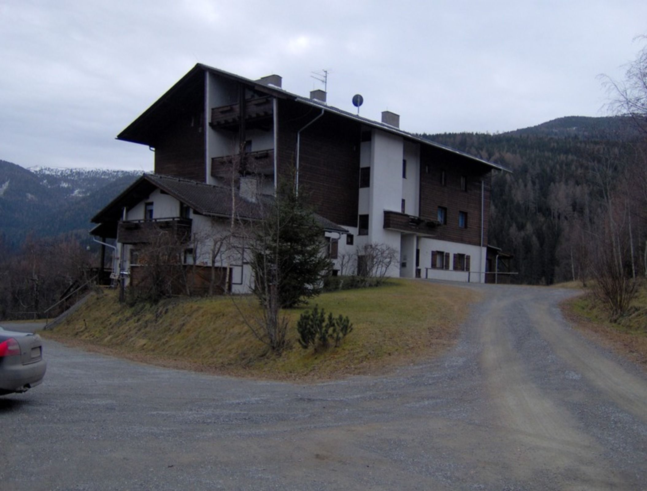 Un bâtiment à deux étages, doté d’un toit en pente, d’une cheminée bien visible et d’un petit espace porche.