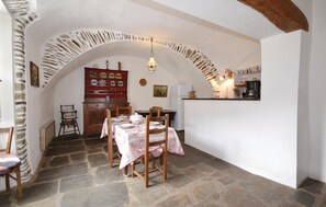 Enjoy meals in this inviting dining area with a stone archway leading to the kitchen.