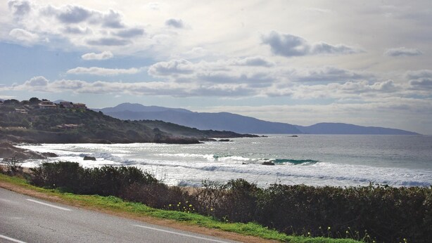 A coastal road with a view of the ocean and distant mountains. - Nice apartment in Sagone with kitchen (Sagone)