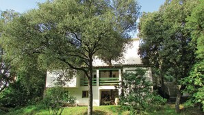 A two-story building with a green and white facade, surrounded by trees. - Nice apartment in Sagone with kitchen (Sagone)