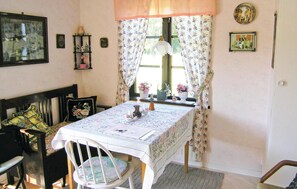 Enjoy a home-like dining experience with a table set for two, featuring a floral tablecloth and comfortable seating.
