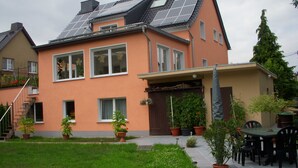 A house with solar panels, a covered patio, and potted plants. - Apartment OG - Apartment / DZ Blesse Allstedt (Allstedt)