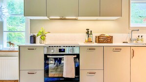 A kitchen with a built-in oven, a sink, and cabinets. - 3 bedroom awesome home in Västervik (Västervik)