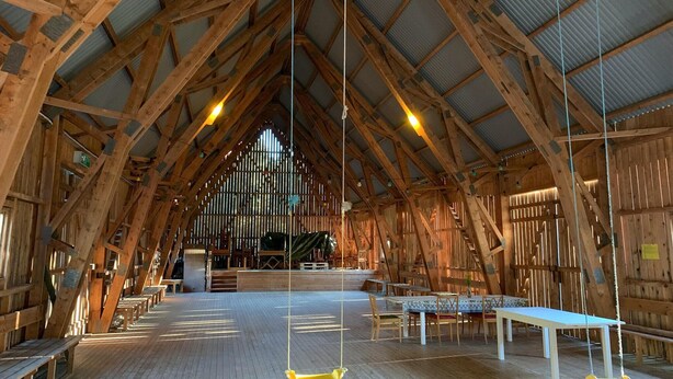 A spacious hall with high wooden beams, a central staircase, and a long table with chairs. - 3 bedroom awesome home in Västervik (Västervik)