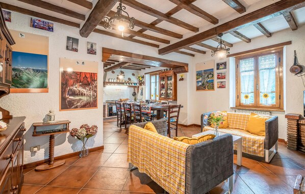 A cozy interior with a dining area, a sofa, and a kitchen in the background.