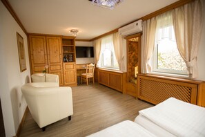 Una habitación con sofá, sillón, escritorio y cama.