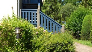A pathway leading to a building with a blue staircase and a door. - Residence Störtebeker Whg. FB20-18 .. - Residenz Störtebeker Whg. 18 (Kühlungsborn)