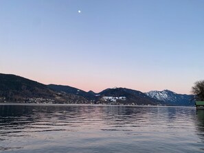 Un lac paisible, avec des montagnes en arrière-plan et un ciel dégagé.