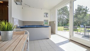 A modern kitchen with a blue countertop, a wooden table, and a potted plant. - 4 bedroom amazing home in Ebeltoft (Ebeltoft)