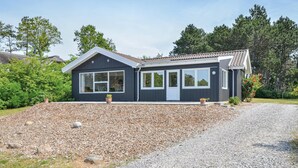 A two-story house with a dark exterior, large windows, and a sloped roof. - 4 bedroom amazing home in Ebeltoft (Ebeltoft)