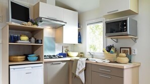 A modern kitchen with white cabinets, a built-in stove, a microwave, and a dishwasher.