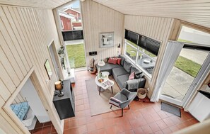 A cozy living area with a sofa, a coffee table, and a chair. There is a window with blinds, a door, and a view of the outside. - Amazing home in Sydals with WiFi (Sydals)