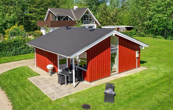 A red metal shed with a covered patio area, a barbecue grill, and a window. - Amazing home in Sydals with WiFi (Sydals)