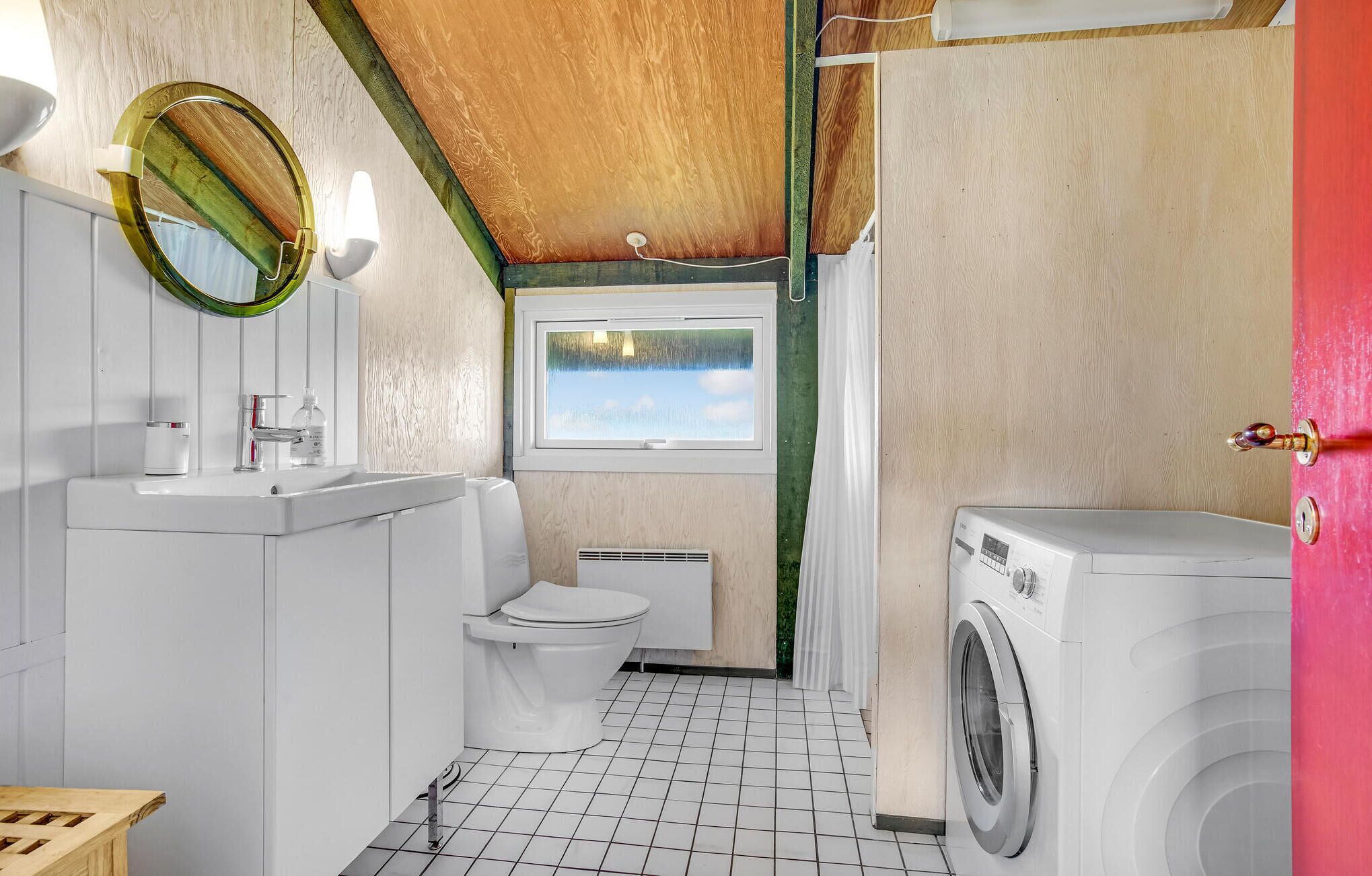 Ein kleines Badezimmer mit Toilette, Waschbecken und Waschmaschine.