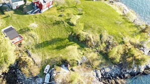 An aerial view of a coastal property with a house, a small boat dock, and a rocky shoreline. - Amazing home in Jondal with WiFi (Jondal)