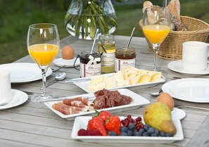 A breakfast table with various food items, including fruits, meats, and condiments. - Great Ocean - Kells apartments (Klink)
