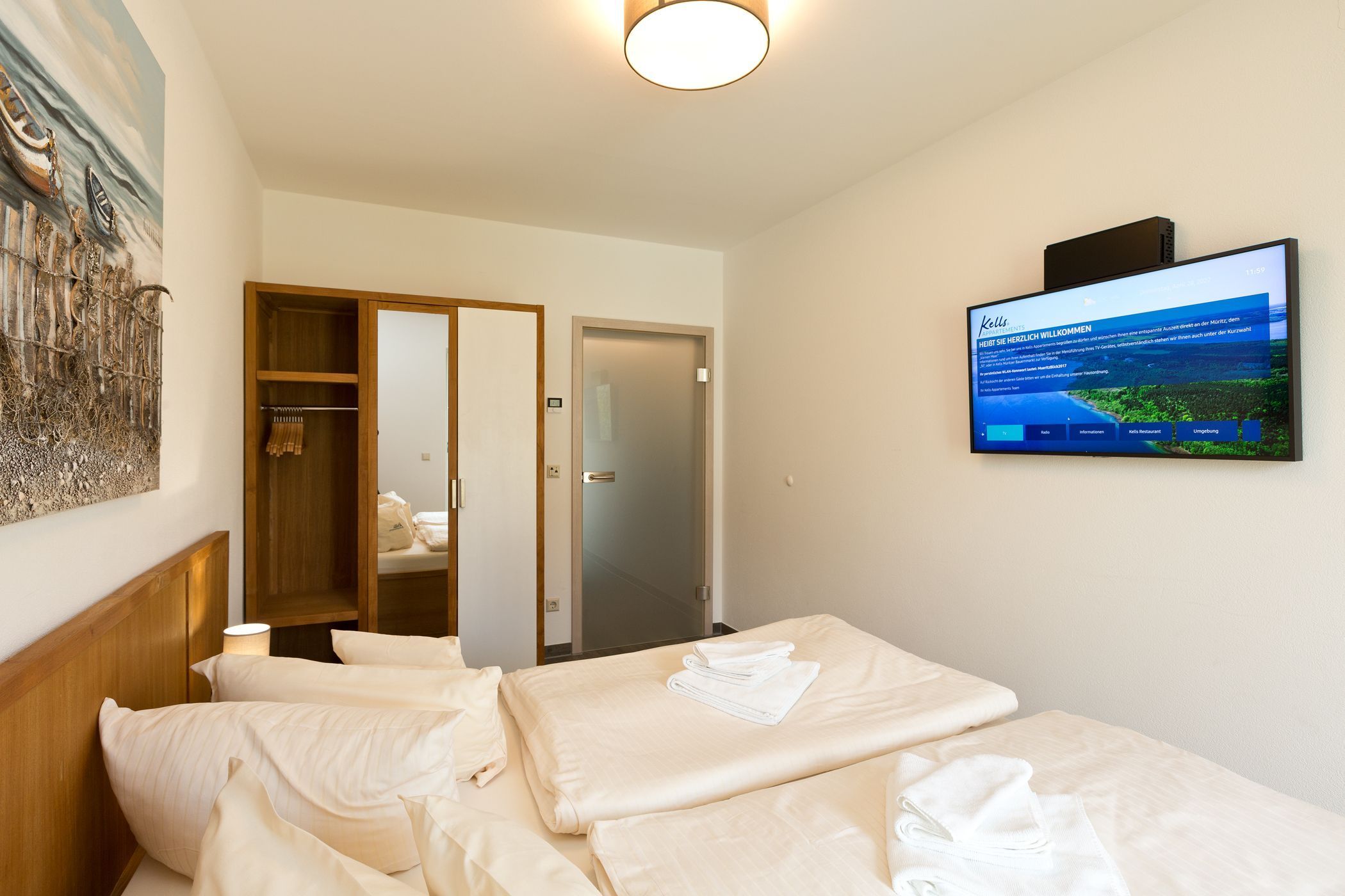 Ein Hotelzimmer mit einem Bett, einem an der Wand montierten Fernseher und einer Tür zu einem Badezimmer.