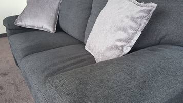 En grå sofa med to puder.