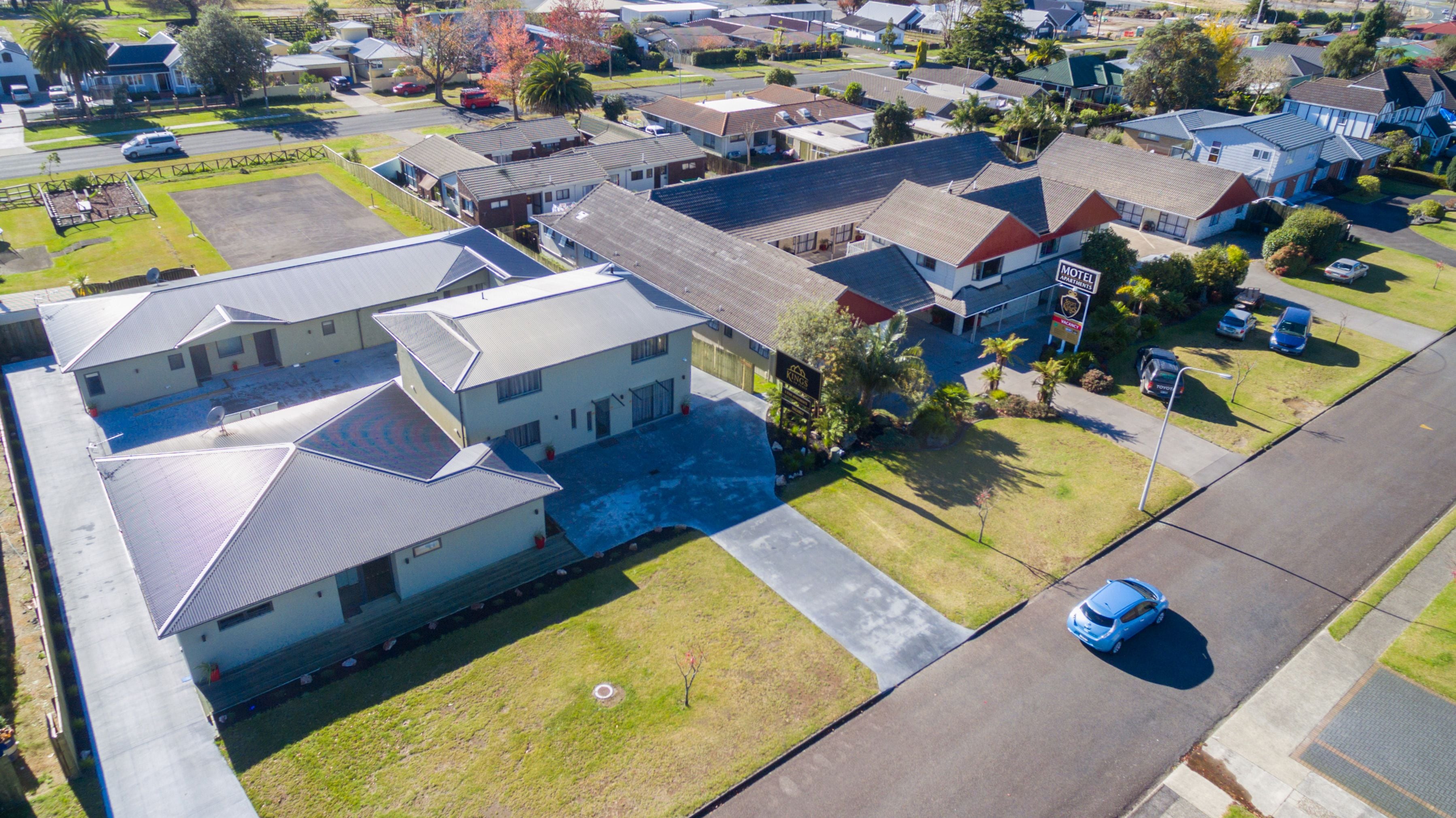 An aerial view of a residential neighborhood with houses, a motel, and a parking lot.