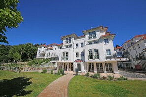 A large, multi-story building with a prominent entrance and a name sign. - F: House Meeresblick A 2.09 Island paradise with balcony - House Meeresblick A 2.09 (Baabe)