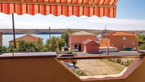 Vista costera con una casa de playa, un coche aparcado y un cielo despejado.