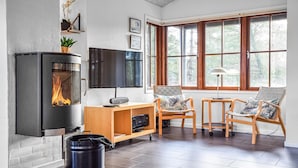 A cozy living room with a fireplace, a TV, and comfortable seating.