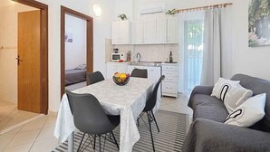 A compact living space with a dining area, kitchenette, and a sofa.