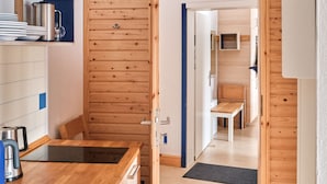 Una cocina con gabinetes de madera, un lavamanos y una cafetera.