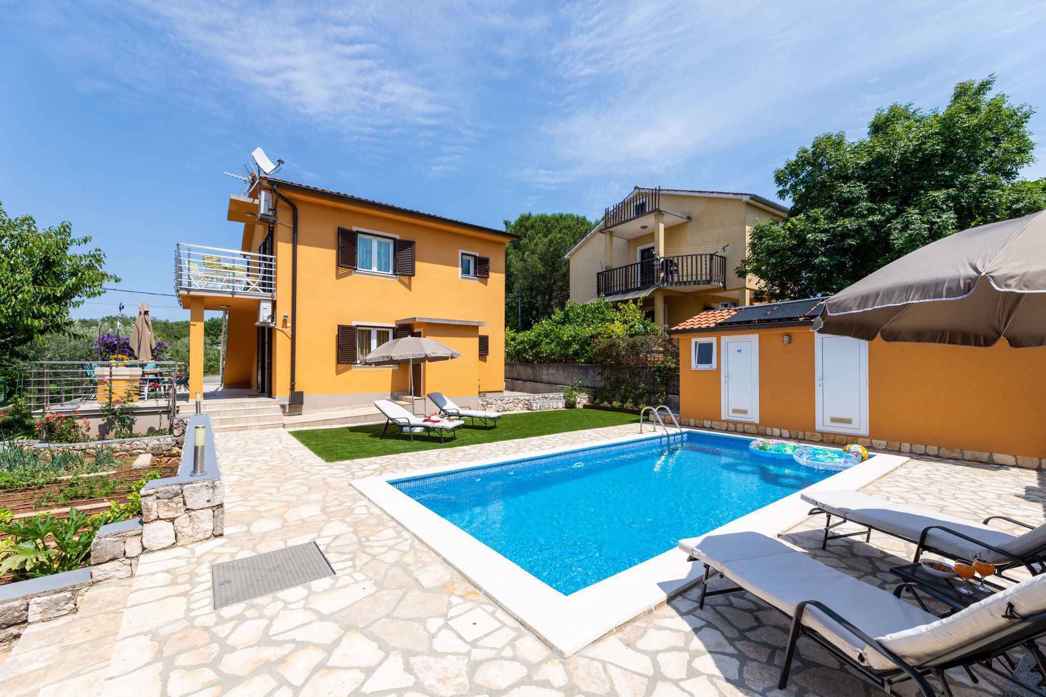 Ein Wohnhaus mit Swimmingpool, Sitzgelegenheiten im Freien und einem Garten.