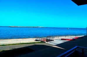 A coastal walkway with a railing, a bench, and a distant shoreline. - Sino Suite, 2. OG, balcony seafront, - Dünenblick Apartments (Helgoland)