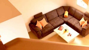 A cozy corner with a brown leather sofa, a white coffee table, and a small lamp. - Vacation apartment 1 - 55 sqm (2-4 persons), balcony - Weichaer Hof FBS Sonja Fritsch (Weißenberg)