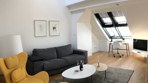 A modern living room with a grey sofa, yellow armchairs, a white coffee table, and a TV. - Apartment 08 - gate to the sea (Helgoland)