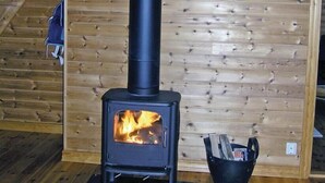 Ein Kaminofen in einem Raum mit Holzwänden und einer Treppe.