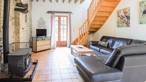 A cozy living room with a fireplace, a sofa, a coffee table, and a staircase leading to an upper level. - Beautiful home in St. Pierre Langers (St. Pierre Langers)
