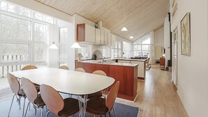 A spacious kitchen with a large island, wooden ceiling, and ample natural light from large windows. - 4 bedroom awesome home in Hasle (Hasle)